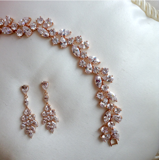 Rose gold earrings and bracelet with multi sizes and shapes of silver crystal in a delicate leaf pattern.